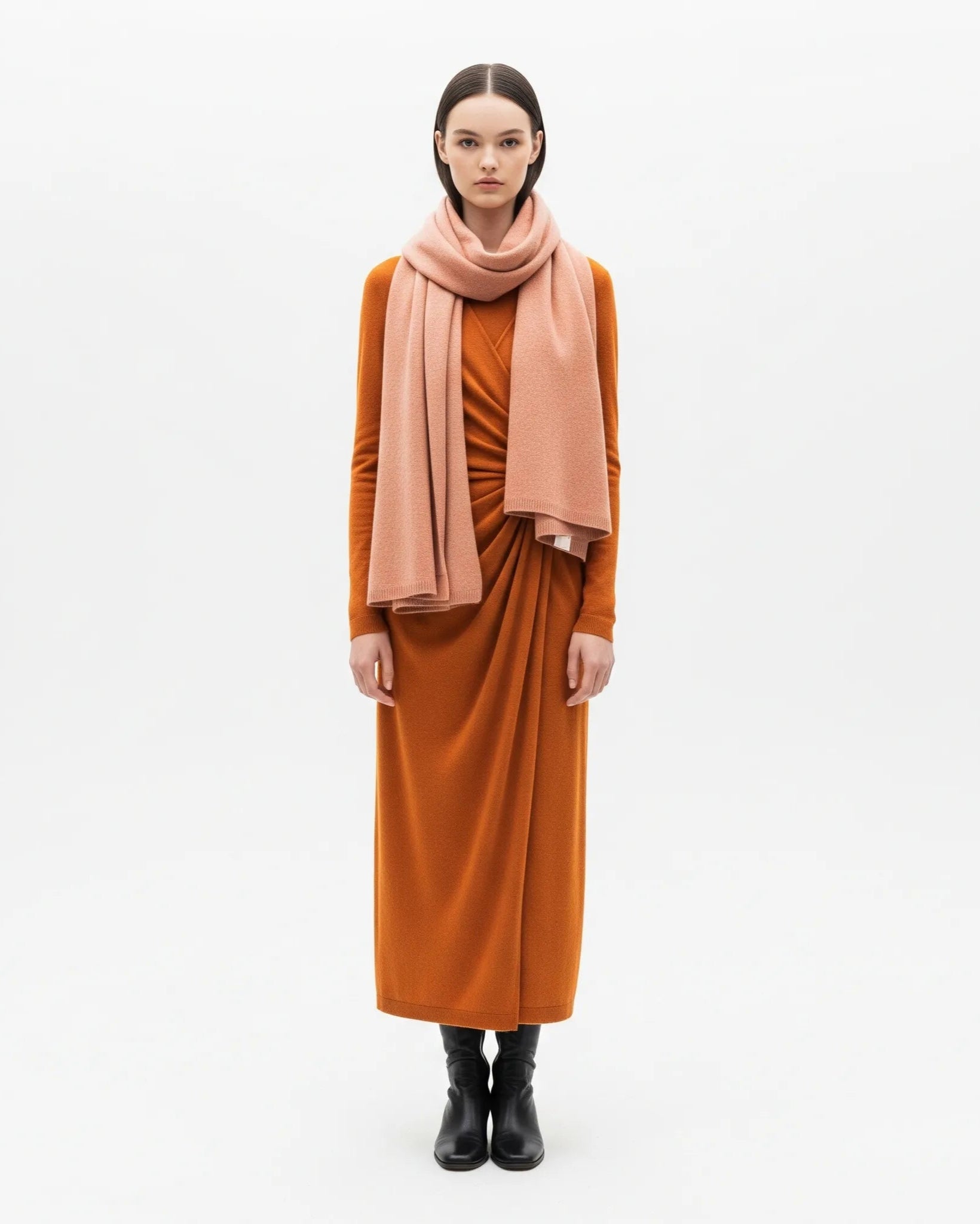 Woman wearing a rust-colored dress and scarf on a white background