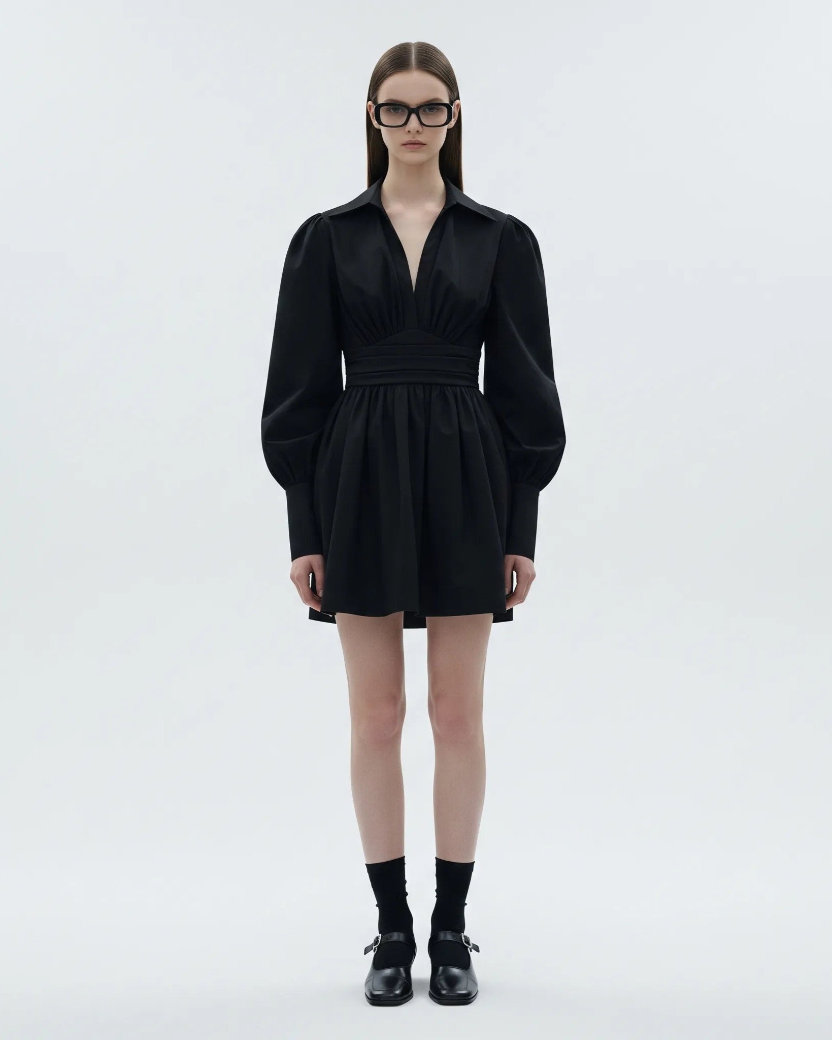 Model wearing a black dress on a white background